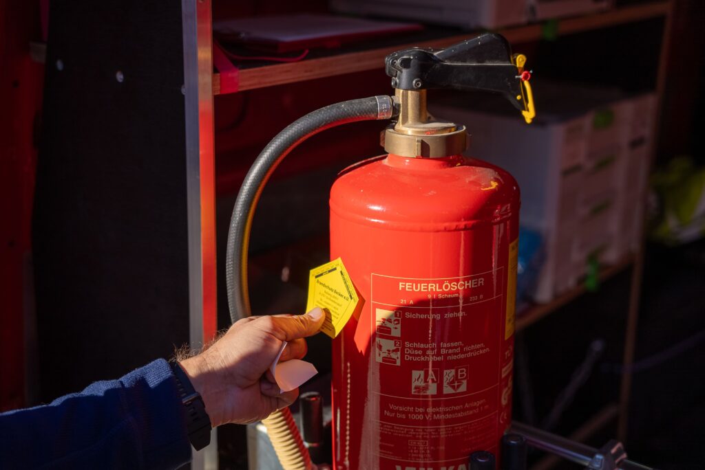 Ein Feuerlöscher wird geprüft und mit einem Sticker als Zertifizierung versehen